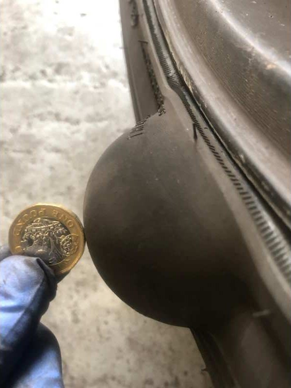Bodywork dent checked against a coin