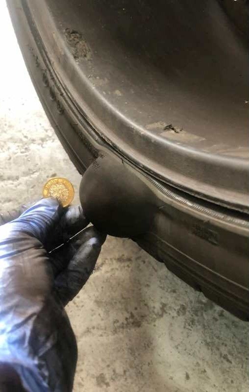 Dent in a panel checked against a coin