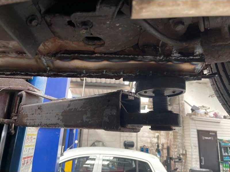 Suspension and exhaust components under a car on the lift